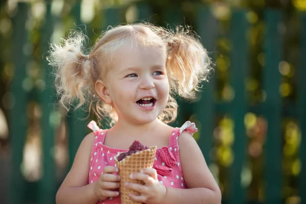 Glückliches kleines Mädchen isst Beeren im Sommer Garten, im Freien. — Stockfoto