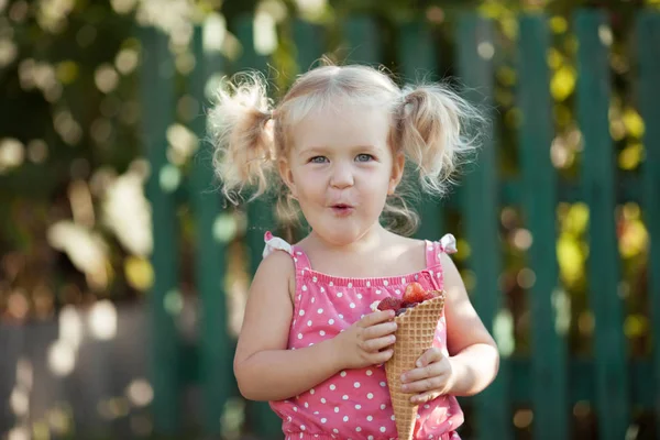 Ευτυχισμένο κοριτσάκι τρώει μούρα σε καλοκαιρινό κήπο, υπαίθριος. — Φωτογραφία Αρχείου