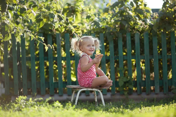 Happy Little Girl jedzą jagody w ogrodzie letnim, na zewnątrz. — Zdjęcie stockowe