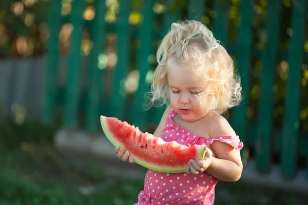Glückliches kleines Mädchen isst Wassermelone im Sommer Garten, im Freien. — Stockfoto