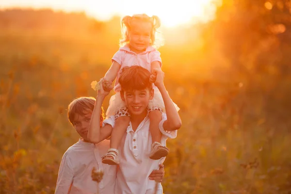 Porträtt av ganska glad syster och bröder i suummer, utomhus — Stockfoto