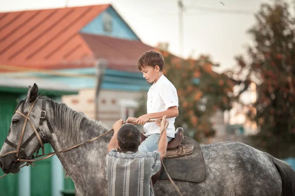 小男孩自信地骑着马在田里飞奔 — 图库照片