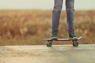 Genç mutlu sevimli kız yolda açık kaykay sürmek