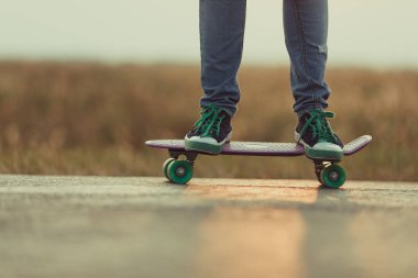 Genç mutlu sevimli kız yolda açık kaykay sürmek