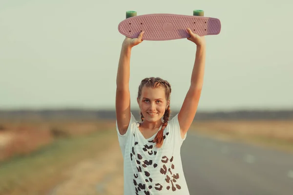 Mladý šťastný roztomilý dívka jezdí na skateboardu na silnici, venkovní — Stock fotografie