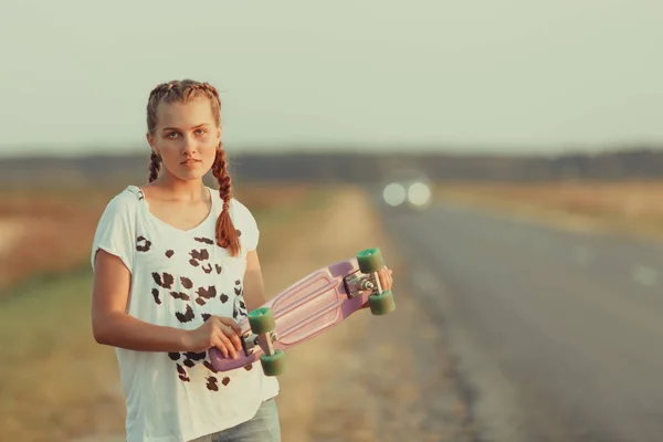 Mladý šťastný roztomilý dívka jezdí na skateboardu na silnici, venkovní — Stock fotografie