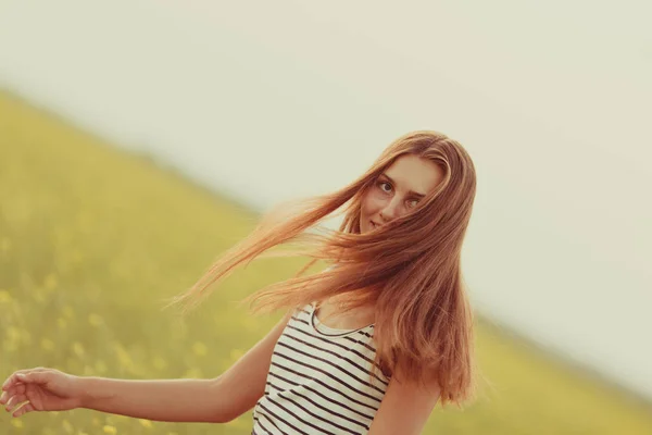 Sarı çiçekler, yaz, gün batımı ile bir alanda güzel bir kız portresi — Stok fotoğraf