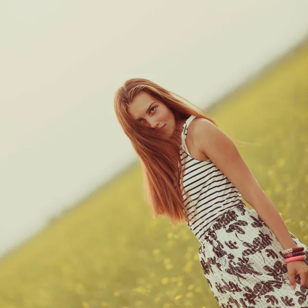 Porträt eines schönen Mädchens auf einem Feld mit gelben Blumen, Sommer, Sonnenuntergang — Stockfoto