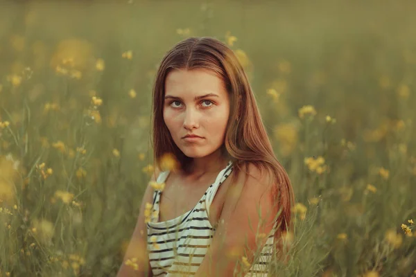 Portrait d'une belle fille dans un champ avec des fleurs jaunes, été, coucher de soleil — Photo