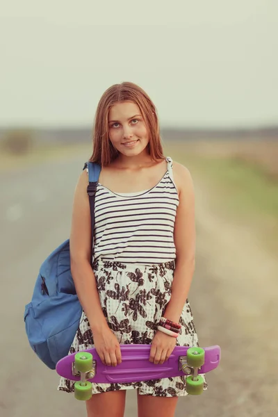 Junge glückliche süße Mädchen fährt Skateboard auf der Straße, im Freien — Stockfoto