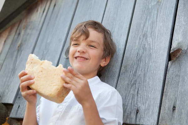 Retrato de chico divertido, niño feliz comiendo una barra de pan —  Fotos de Stock