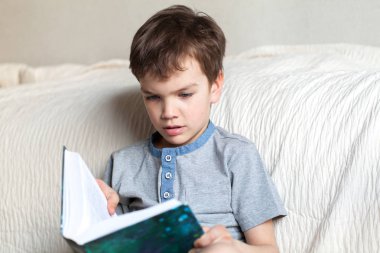 Çocuk odada kanepede bir kitap okuma