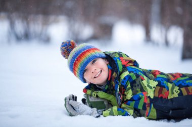 Winter park, açık oynayan neşeli mutlu çocuk