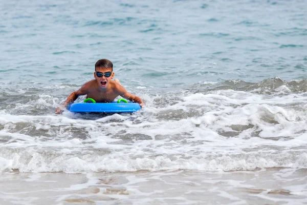 Ritratto di felice ragazzo carino che nuota in mare, tavola da surf, outdoor — Foto Stock