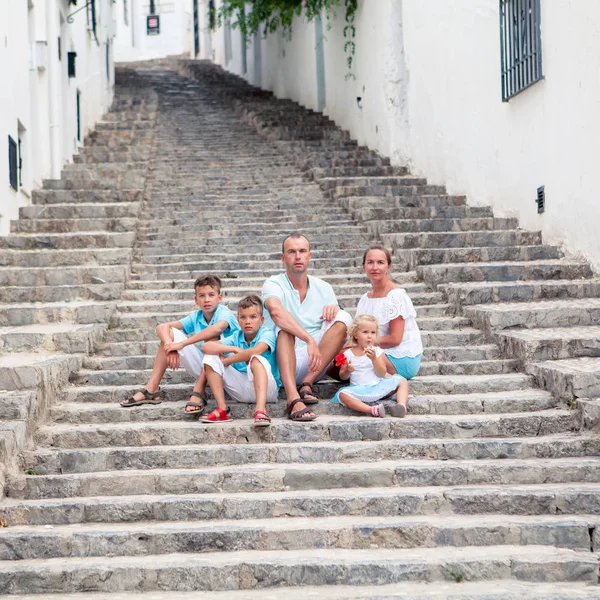 Big Family vacation in Europe. parents and children at street of typical spain traditional village.