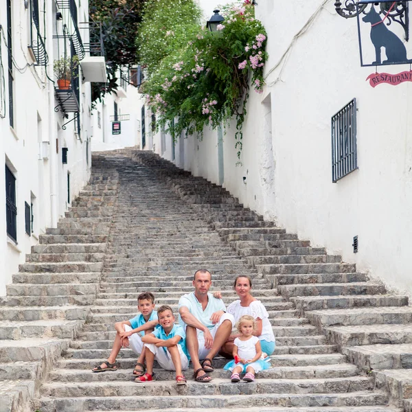 Big Family vacation in Europe. parents and children at street of typical spain traditional village.