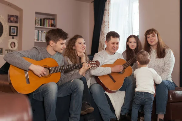 大家族の肖像画、子供と両親が一緒に歌い、一緒にギターを演奏し、屋内 — ストック写真