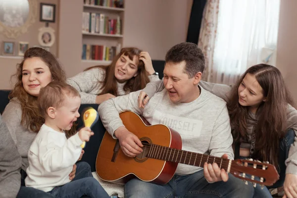 Retrato de uma grande família, crianças e pais cantam e tocam guitarra juntos, interior — Fotografia de Stock