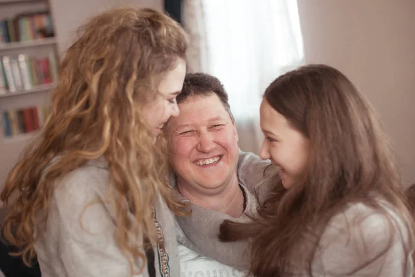 Retrato de un padre feliz y hermosas hijas, se ríen, interior —  Fotos de Stock