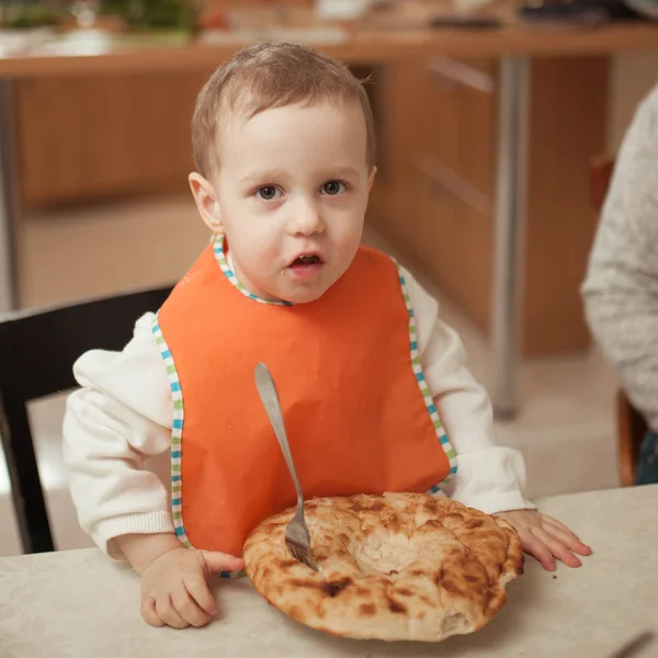 Niño comiendo pan en la cocina —  Fotos de Stock