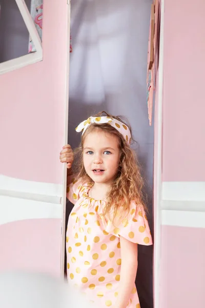 Kis aranyos boldog lány a háttérben a rózsaszín busz, ünnep, party. — Stock Fotó