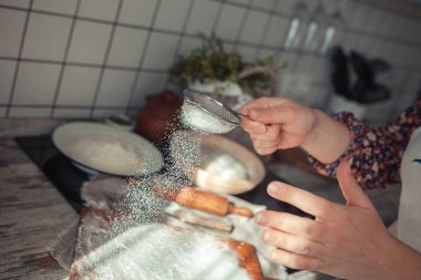 Pişirme malzemeleri ahşap masaya yerleştirilir, pişirmeye hazır. Gıda hazırlama konsepti, evde ekmek yapma, arka planda mutfak.