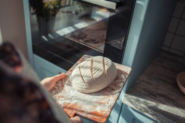 Pişirme malzemeleri ahşap masaya yerleştirilir, pişirmeye hazır. Gıda hazırlama konsepti, evde ekmek yapma, arka planda mutfak.