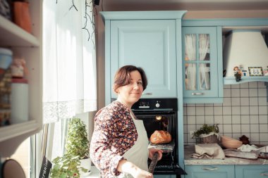 Pişirme malzemeleri ahşap masaya yerleştirilir, pişirmeye hazır. Gıda hazırlama konsepti, evde ekmek yapma, arka planda mutfak.