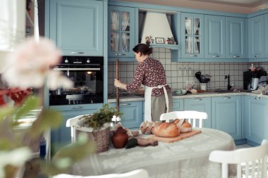 Pişirme malzemeleri ahşap masaya yerleştirilir, pişirmeye hazır. Gıda hazırlama konsepti, evde ekmek yapma, arka planda mutfak.