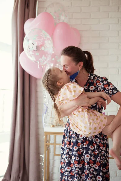 Счастливые мама и дочь на дне рождения в доме — стоковое фото