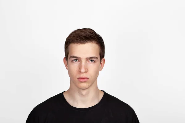 Porträt eines jungen, gut aussehenden Mannes in schwarzem T-Shirt vor weißem Hintergrund. — Stockfoto