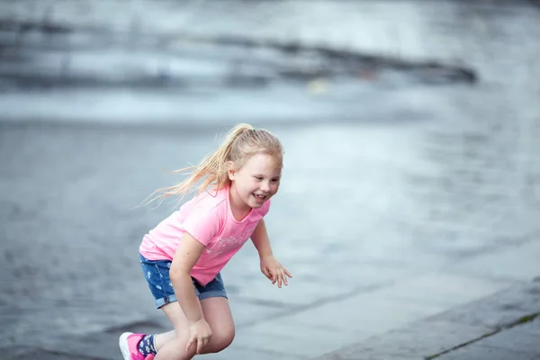 Petite fille mignonne marchant près de la fontaine, en plein air — Photo