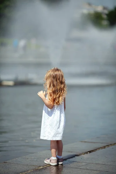 Küçük sevimli kız çeşme yakınında yürüyüş, açık — Stok fotoğraf