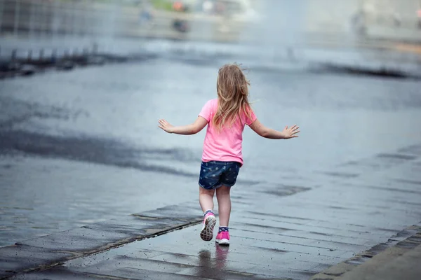 Kleines nettes Mädchen zu Fuß in der Nähe des Brunnens, im Freien — Stockfoto