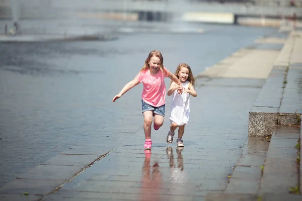 Kleine süße Mädchen, die in der Nähe des Brunnens spazieren gehen, im Freien — Stockfoto