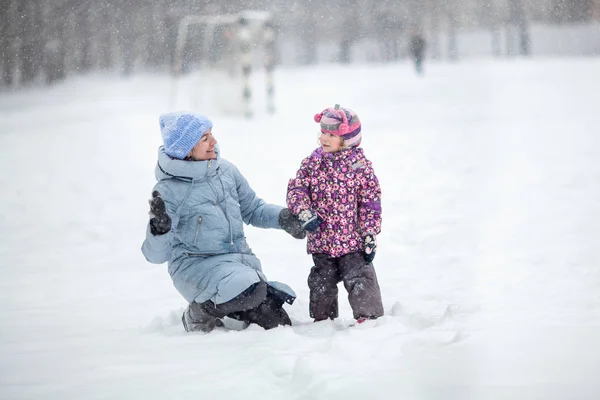 Promenade en famille dans le parc d'hiver. Mère et fille heureuses jouant dehors . — Photo