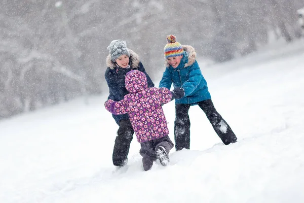 Caminhe crianças divertidas no parque de inverno. Feliz irmão e irmã brincando lá fora . — Fotografia de Stock