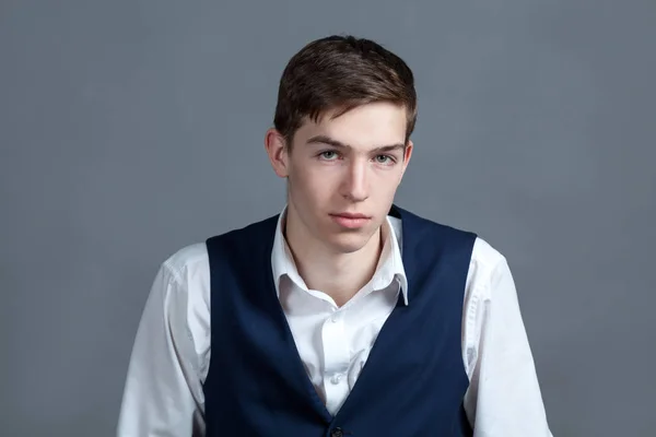 Retrato de adolescente colegial feliz en camisa blanca y chaqueta sobre fondo gris — Foto de Stock