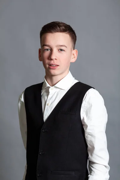 Retrato de adolescente colegial feliz en camisa blanca y chaqueta sobre fondo gris — Foto de Stock