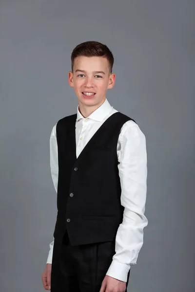 Retrato de adolescente colegial feliz en camisa blanca y chaqueta sobre fondo gris —  Fotos de Stock