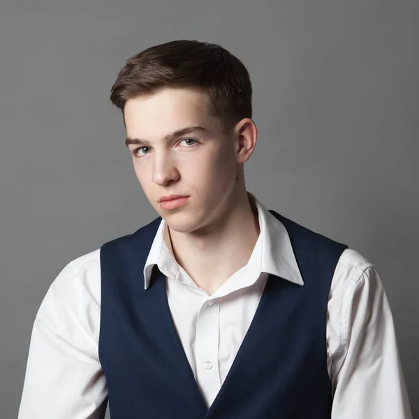 Retrato de adolescente colegial feliz en camisa blanca y chaqueta sobre fondo gris — Foto de Stock