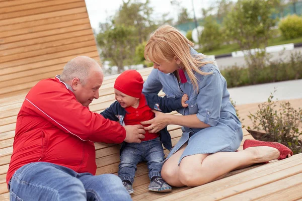 Lycklig familj med ett litet barn på en promenad i en sommarpark. Vila i staden. — Stockfoto