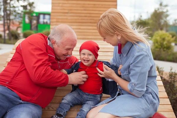 Gelukkige familie met een klein kind op een wandeling in een zomerpark. Rust in de stad. — Stockfoto