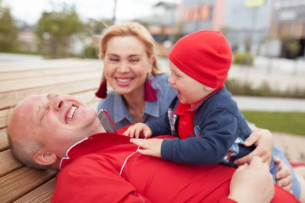 Lycklig familj med ett litet barn på en promenad i en sommarpark. Vila i staden. — Stockfoto