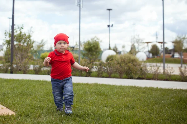 Criança pequena feliz em passeio em um parque de verão. Descanso na cidade, ao ar livre — Fotografia de Stock