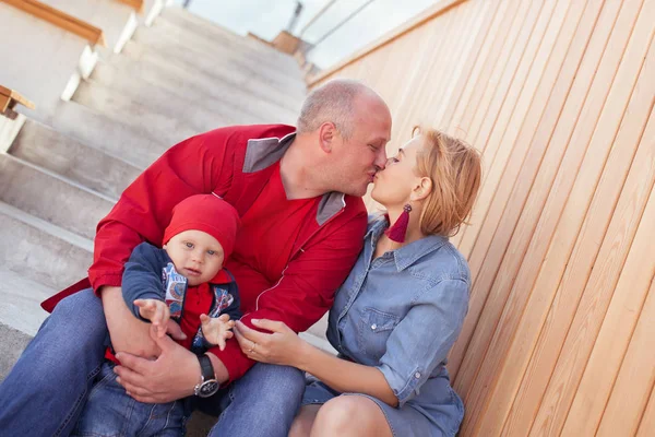 Famiglia felice con un bambino piccolo in una passeggiata in un parco estivo. Riposo in città . — Foto Stock