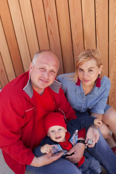 Família feliz com uma criança pequena em um passeio em um parque de verão. Descanso na cidade . — Fotografia de Stock