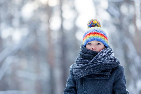 Retrato de niño triste en abrigo negro para caminar en el parque de invierno, al aire libre —  Fotos de Stock