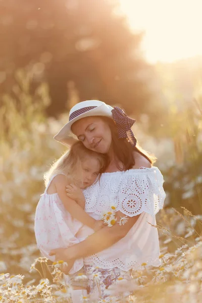 Gelukkige familie moeder met schattige kleine kind meisje in de Kamille veld in de zomer — Stockfoto