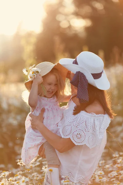 夏のカモミールフィールドでかわいい小さな女の子と幸せな家族の母 — ストック写真